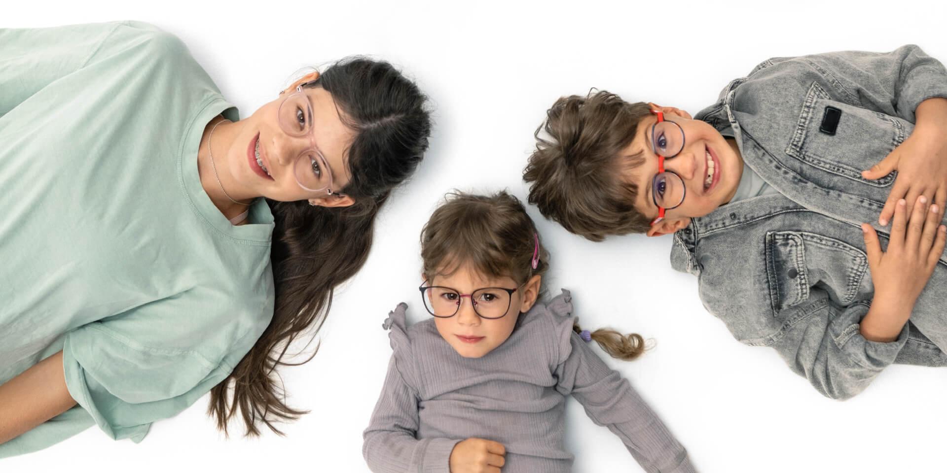 청소년 한 명과 어린이 두 명이 자이스 근시 관리 렌즈를 착용하고 바닥에 누워 있다.