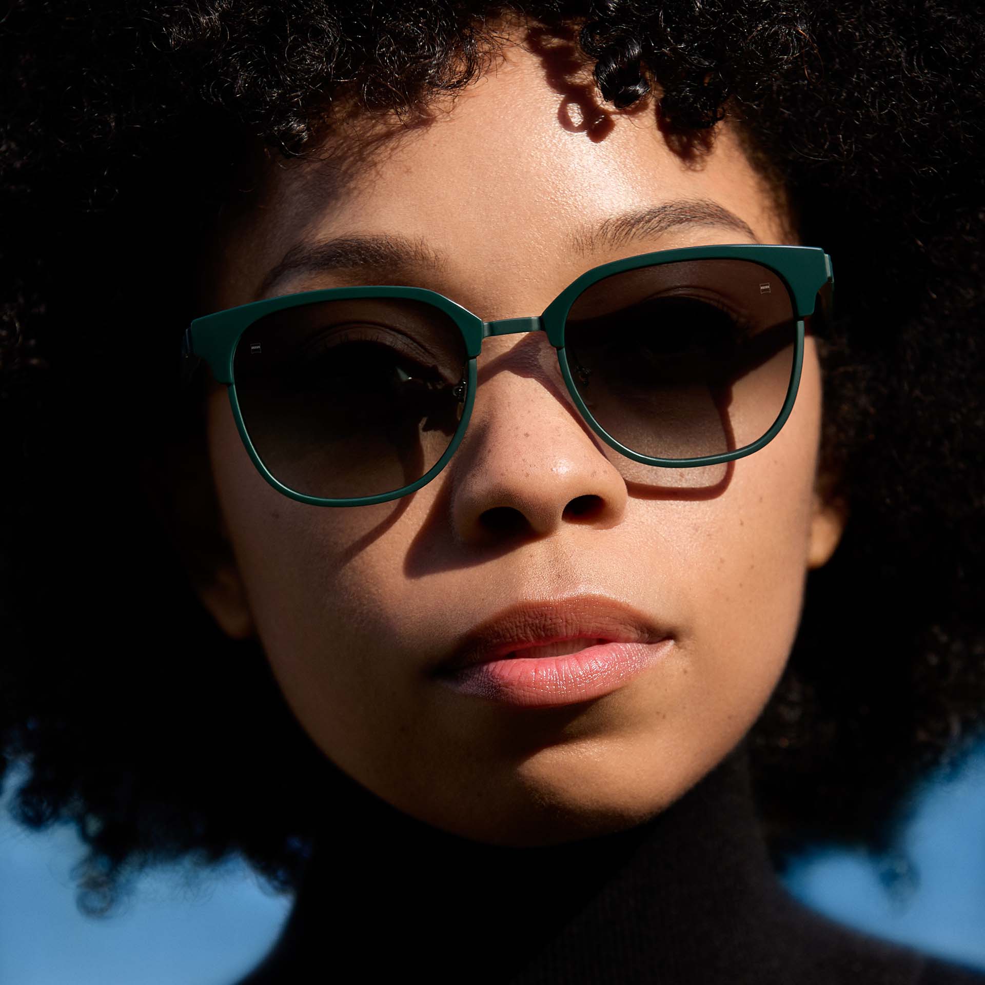 그라데이션 착색 렌즈가 장착된 녹색 프레임 선글라스를 착용한 여성 