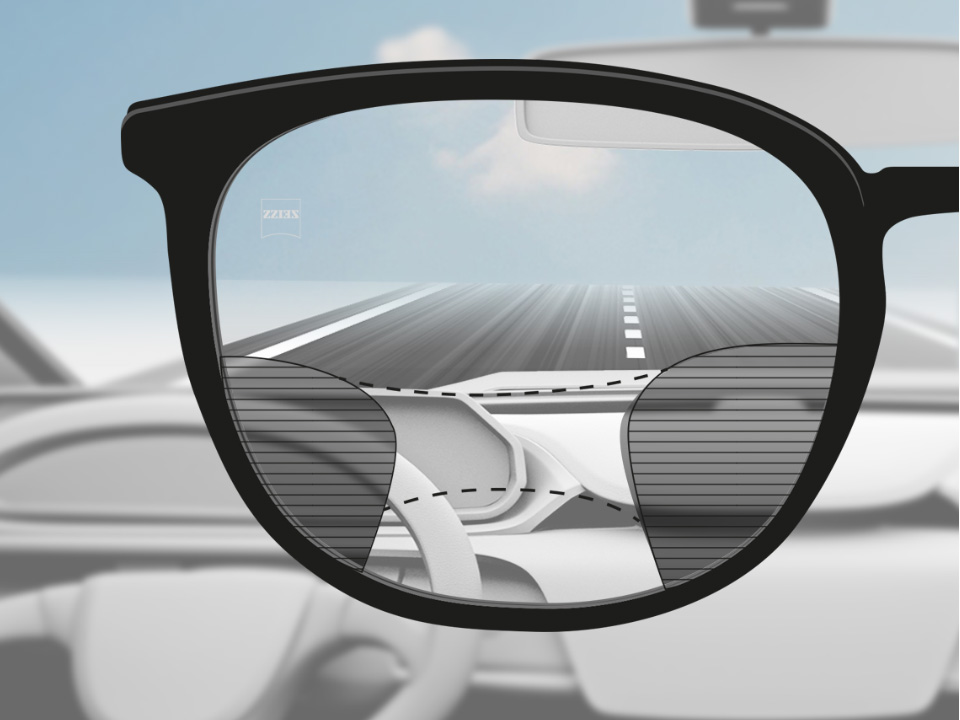 자이스 드라이브세이프 누진 렌즈를 착용한 운전자의 시점에서 본 모습. 도로와 대시보드가 선명히 보이고 왼쪽과 오른쪽 부분이 흐릿하다. 